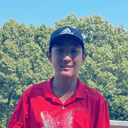 Asian high school male student golfer at a tournament and holding a trophy