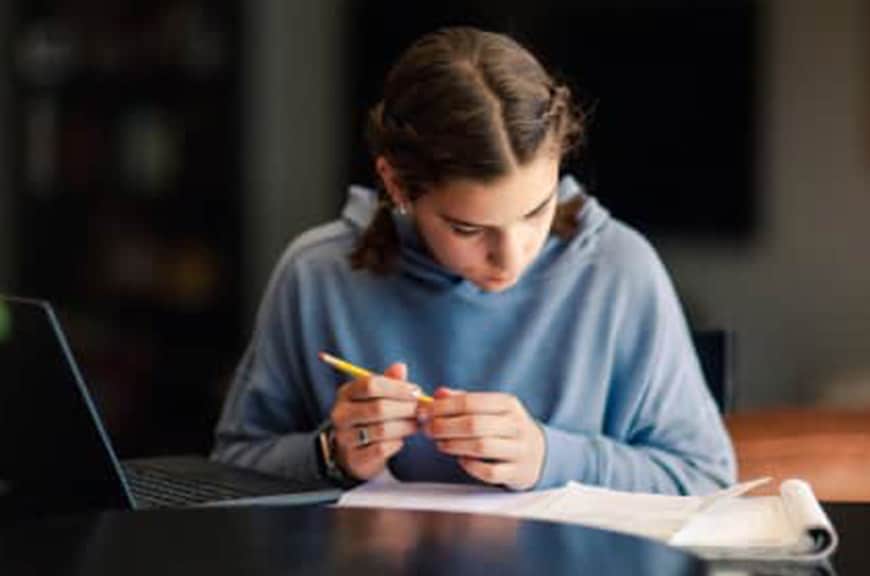 female teenager reading and taking notes