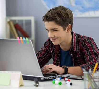 teenage male in front of laptop plaid shirt